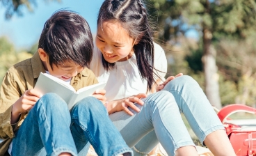 外で本を読む子供